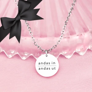 Halsband med text - Elegant smycke med en rund berlock som har texten 'andas in andas ut'. Kedjan är fin och smidig, perfekt för daglig användning. 