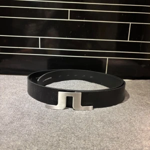 Svart skärp med silverfärgat spänne från j lonberg - Snyggt svart skärp i äkta skinn med ett stilrent silverfärgat spänne. Tillverkat i Italien och passar midjemått 100 cm. Perfekt för att ge en elegant touch till din outfit.