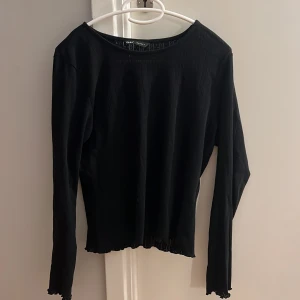 Svart ribbad tröja från ONLY - Säljer en stilren svart ribbad tröja från ONLY. Tröjan har långa ärmar och en klassisk rund halsringning. Perfekt för en enkel och snygg look.