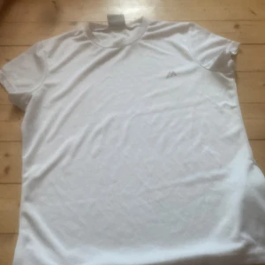 Vit t-shirt från Martes Essentials - Säljer en klassisk vit t-shirt från Martes Essentials i storlek M. T-shirten har en enkel design med korta ärmar och en liten logga på bröstet. Perfekt för en avslappnad stil.