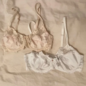 Två spetsbehåar i vitt och beige 75B - Två behåar, en i vitt och en i beige. Otroligt sköna och sitter snyggt, men fel storlek för mig. Från bodyflirt. 100 för den beiga då den är lite mer använd och 150 för den vita. 