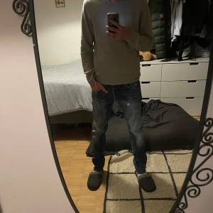 Replay jeans med slitningar  - Säljer ett par snygga blå jeans från Replay. De har en klassisk femficksdesign med slitna detaljer och en knappgylf. Perfekta för en avslappnad stil.