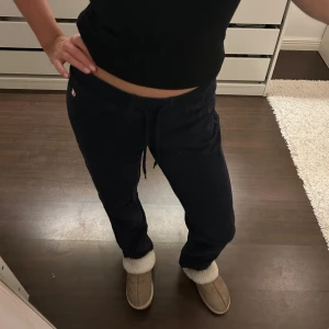 Mörkblå  mjukisbyxor med snörning - Säljer ett par bekväma svarta mjukisbyxor med snörning i midjan. Perfekta för en avslappnad dag hemma eller en snabb tur till affären. Byxorna har en normal passform och är tillverkade i mjukt material för extra komfort.