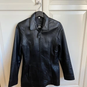 Läderjacka - Svart läderjacka i mycket gott skick. Det finns en liten skada, se sista bilden.   Det står att den är strl L men skulle nog snarare säga att det är en strl M