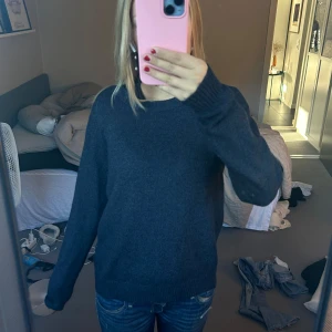 Mörkgrå tröja - Säljer en mysig mörkgrå tröja med långa ärmar. Perfekt för höst och vinter, den är både stilren och bekväm. Tröjan har en normal passform och är gjord i ett mjukt material som håller dig varm under kyliga dagar. Perfekt att matcha med jeans för en avslappnad look.