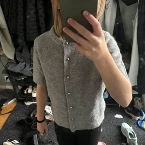 Stickad t-shirt med silvriga knappar - En grå mjuk stickad t-shirt med silvrig knappar från ZARA i storlek s