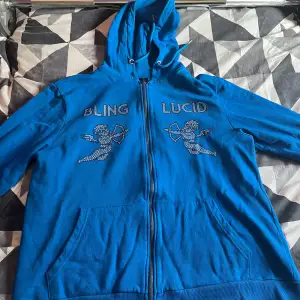 Blå bling lucid zip hoodie, använd ca 2 ggr så nästan ny, anledningen varför den säljs är för den satt för stort på mig överlag, inga defekter, hör av dig vid frågor angående pris eller liknande 