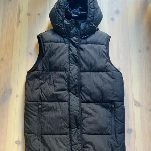 Puffer väst Zara - Praktisk och lättviktig väst med avtagbar huva och justerbar midja. Bra skick. Storlek XS, passar 34-36 