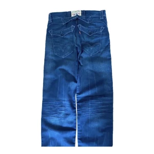 Vintage Levis Jeans - Vintage Levi’s jeans med coola fickor. Jeansen är i mycket bra skick utan fläckar eller skador. Känn dig fri att fråga om du undrar något!