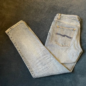 Ljusblåa nudie jeans - Ljusblåa nudie jeans i modellen Gritty Jackson, dessa jeans har mer av en straight fit och passar er som inte gillar för tajta samt för lösa jeans.