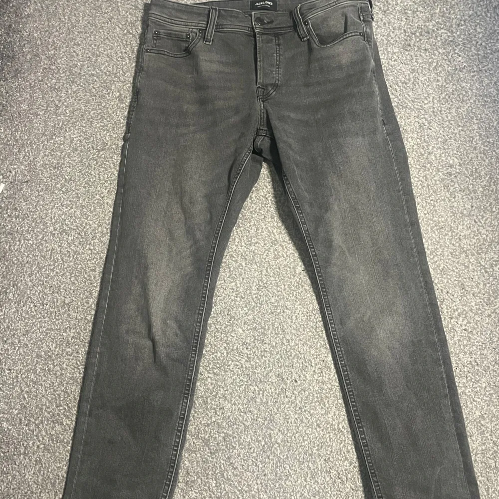 Säljer ett par snygga grå jeans från Jack & Jones. De har en klassisk femficksdesign och är i storlek 32/30. Perfekta för både vardag och fest! De är i bra skick och har en stilren look.. Jeans & Byxor.