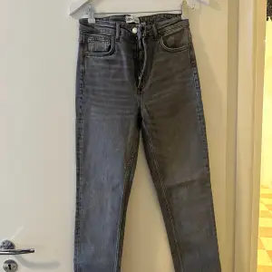 Säljer ett par snygga grå jeans från Zara i storlek 38. De har en klassisk design med dragkedja och knapp framtill. Perfekta för både vardag och fest!