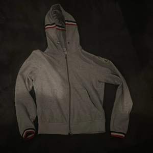 Grå Moncler Hoodie i storlek M. (Liten i storleken)  Tillkommer Kvitto från NK. Slarvat tyvärr bort snöret. 9/10 skick.