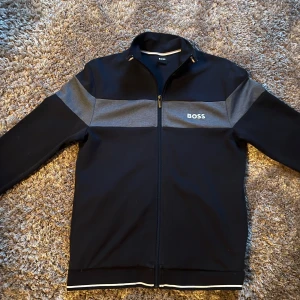 Hugo boss Full zip - Säljer just nu denna feta full-zip tröja från Hugo boss pågrund av att det används aldrig, har dock inget kvitto men vill minnas att jag köpte den från Zalando. Den är i nyskick har använda 1-2 gånger. Hör av dig vid funderingar och frågor!