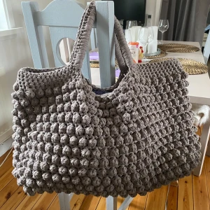 Handgjord virkad väska - weekend bag - Bredd: 69 cm Höjd (utan handtag inräknat): 32 cm  Rymlig stor weekend bag som jag har virkat själv!   Rymmer mycket och starka handtag för mer packning. Nyskick!   Material: 700 kr Pris: 1300 kr 