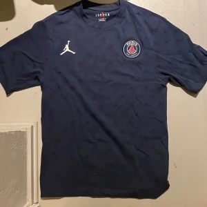 Paris Saint German t-shirt - blå Paris Saint German t-shirt från Jordan. Den är i storlek xs men sitter som S. Helt oanvänd och taggen är kvar vilket man ser på bild två. Pris kan diskuteras. Kontakta vid funderingar!