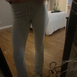 Grå mjukisbyxor med snörning - Superbekväma grå mjukisbyxor i en loose passform. Perfekta för mysiga dagar hemma eller en avslappnad dag ute. De har en praktisk snörning i midjan för justerbar passform. Materialet är mjukt och stretchigt, vilket gör dem till ett måste i garderoben!