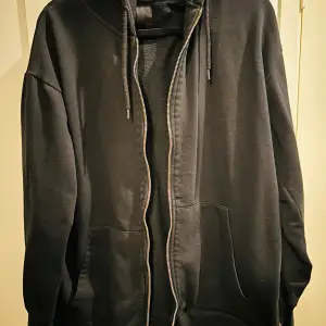 Säljer en svart hoodie från 157 i storlek L. Den har en dragkedja framtill och en skön huva med snörning. Perfekt för höst och vår, och passar till både chill och casual outfits. Den är i bra skick och superbekväm att ha på sig. Hör av dig om du är intresserad!