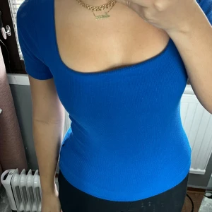 Blå topp med fyrkantig halsringning - En klassisk blå topp i storlek S med en snygg fyrkantig halsringning. Perfekt för både vardag och fest!