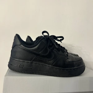 Sneakers - Svarta Nike Air Force 1 i storlek 35,5 (tycker de även passar en 36:a). Använda vid fåtal tillfällen och är i fint skick.