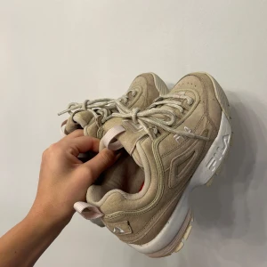 Fila sneakers - Fila sneakers i nyanserna beige mocka och detaljer i rosa och vitt. Använda vid ett fåtal tillfällen så nästintill i nyskick.