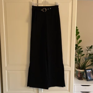 Partybyxa från Bershka  - Säljer ett par snygga partybyxa från Bershka. I nyskick. Storlek S. Bälte medföljer. Vida ben med slits. 96% polyester och 4% elastan 