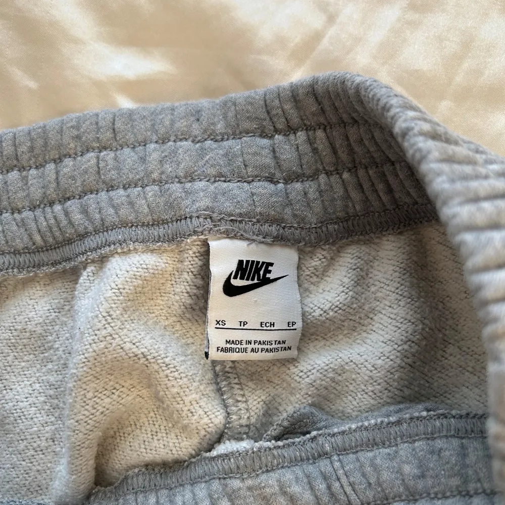 Säljer ett par grå mjukisbyxor med matchande tröja från Nike i storlek XS. Byxorna är superbekväma med elastisk midja och det klassiska Nike-loggan på sidan. Höger ben på byxan har en liten defekt som syns på bilden. . Jeans & Byxor.