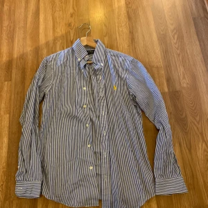 Ralp Lauren skjorta - Skjorta i herrmodell från ralp lauren som är väldigt lite använd. Storleken är xs men på en tjej hade den suttit mer som en m