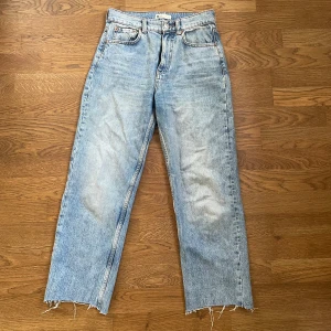 Ljusblå jeans med råa kanter - Säljer ett par ljusblå jeans med en avslappnad look. De har råa kanter vid bensluten och en klassisk femficksdesign. Perfekta för en casual stil och passar till det mesta. De är i bra skick och redo för nya äventyr!