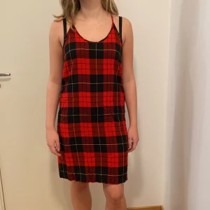 Röd och svart rutig klänning från Cheap Monday - Säljer en supercool röd och svart rutig klänning från Cheap Monday. Den är ärmlös med smala axelband och har en avslappnad passform. Perfekt för både vardag och fest! 🖤
