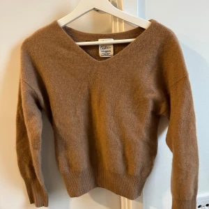 Brun kashmirtröja från FRAY I.D - Säljer en supermjuk och lyxig brun kashmirtröja från FRAY I.D. Tröjan har en v-ringad design och  ärmar med ribbade muddar. Perfekt för höst och vinter när du vill hålla dig varm. I 100% kashmir.  Passar också S. Köpt för 2200