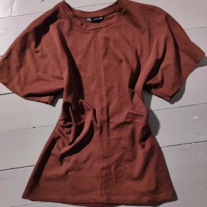 Figursydd t shirt  - Figursydd t shirt I en vindöd/brun färg. 