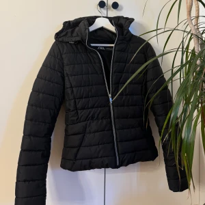 Svart jacka - ZARA  - Svart lite tunnare dunjacka från ZARA. Passar perfekt till höst, vår o lite varmare vinterdagar. Snygg o enkel att styla. Storlek M men skulle säga att den motsvarar mer än xs/s i storlek. Mycket bra skick, inga defekter.