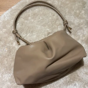 väska - väldigt rymlig väska i beige färg, kan användas som ett necessär också (vilket jag gjort) inga defekter och är i läder material