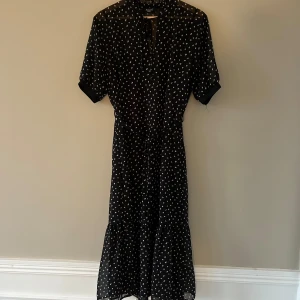 Klänning från Sisters point - Klänning i strl M från Sisters point i gott skick. Mönstret är som asymmetriska prickar i vitt och lite gult. Puffärm och snöre i midjan. Medföljer en underklänning då själva klänningen är lite transparent i tyget.