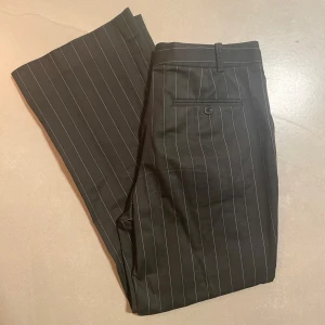 Lågmidjade bootcut kritstrecksrandiga kostymbyxor  - Vintage HM köpta secondhand   