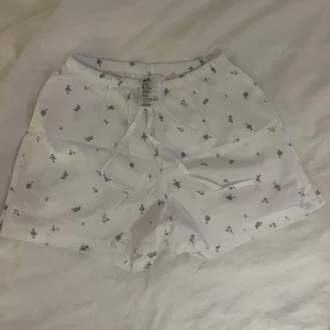 Pyjamasshorts  - Vita pyjamasshorts med blommor på i storlek XS från H&M. Använda få gånger.