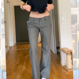 Grå kostymbyxor - Snygga grå kostymbyxor med låg midja och raka ben. Byxorna har knappar fram och är extra långa så passar mig som är 180cm.  