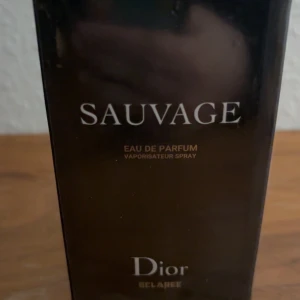 Sauvage Eau de Parfum från Dior - Säljer en elegant och maskulin Eau de Parfum från Dior, Sauvage. Flaskan rymmer 100 ml och kommer i en stilren svart förpackning. Perfekt för den som vill ha en tidlös och kraftfull doft. Passar utmärkt för speciella tillfällen eller som en lyxig vardagsdoft.