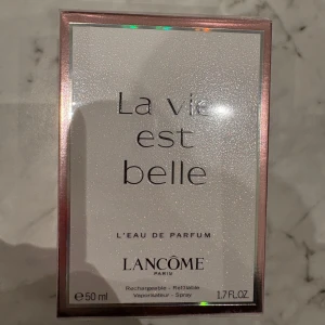 La Vie Est Belle L'Eau de Parfum från Lancôme - Upptäck La Vie Est Belle, en elegant och feminin parfym från Lancôme. Flaskan innehåller 50 ml av denna ljuvliga doft som kombinerar noter av iris, jasmin och apelsinblomma. Perfekt för den som vill känna sig lyxig och självsäker. Parfymen är påfyllningsbar och kommer i en stilren förpackning.