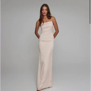 Champagnefärgad klänning  - Champagnefärgad långklänning med smala axelband och öppen rygg.