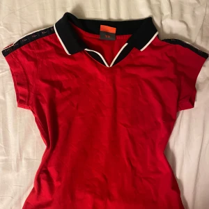 Röd polotopp från Toyon - Säljer en tröja jag fått från min mamma som hon köpt i Kina på 2000-talet. Står M på lappen men passar XS, Inga fel på den annars.