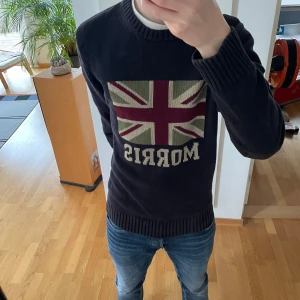 Morris Finstickad Tröja - Säljer en sjukt fet unik mörkblå stickad tröja från Morris. Tröjan har Storbritanniens flagg på sig och är gjord i ett tjockt material. Den är i mycket bra skick och i storlek L men kan även passa strl M. Hör gärna av er vid frågor eller funderingar!!