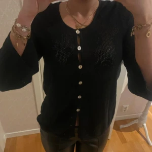 Svart kofta med knappar - Snygg svart kofta med knappar framtill. Koftan har trekvartsärmar och en elegant design som passar perfekt till olika tillfällen. I storlek 36 och märke okänt!
