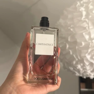 L'Imperatrice parfym från Dolce & Gabbana 100ml - Säljer en elegant parfymflaska av L'Imperatrice från Dolce & Gabbana. Flaskan är genomskinlig med en svart spraykork och har en stilren etikett. Perfekt för den som älskar fräscha och fruktiga dofter.