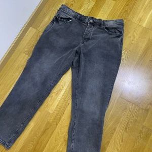 Grå jeansbyxor - OBS: Pris kan diskuteras samt vid snabb affär kan sänkas pris.                              Snygga grå jeansbyxor med en klassisk femficksdesign. De har en diskret tvättad look och stängs med dragkedja och knapp. Perfekta för en avslappnad stil.