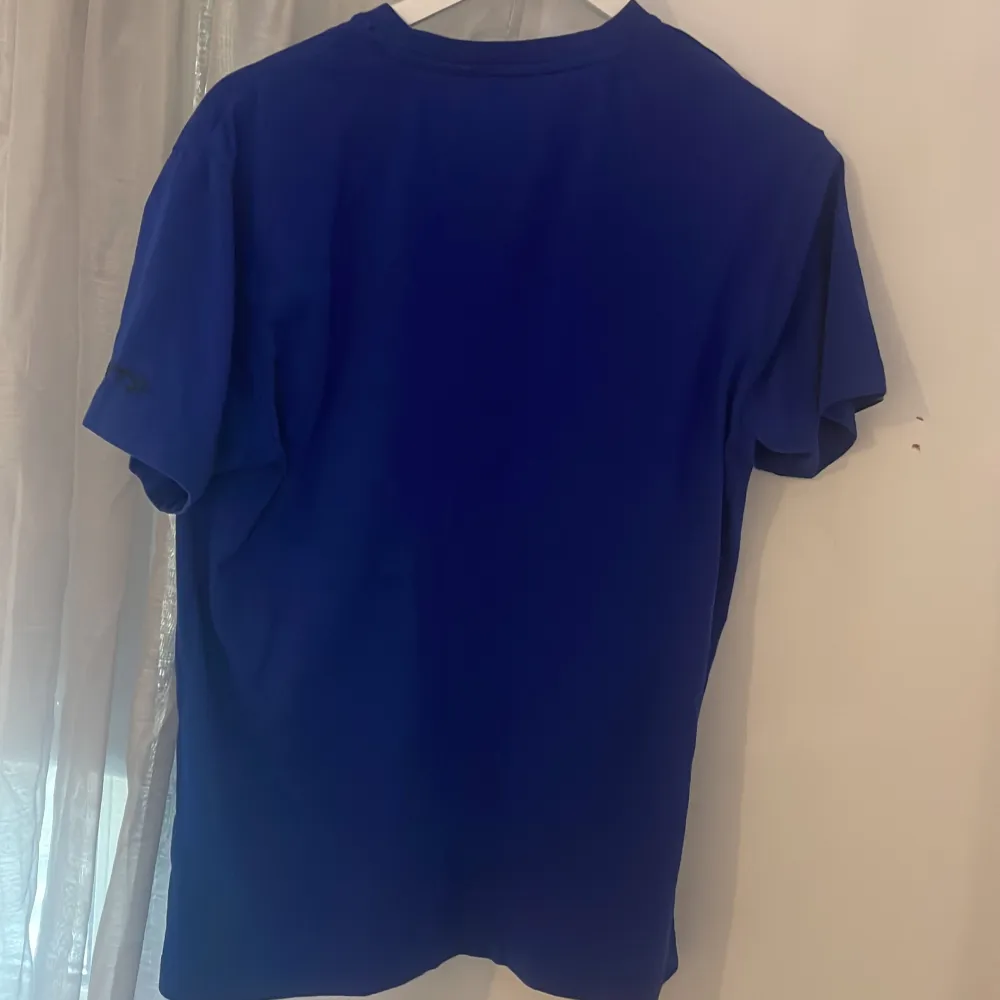 Säljer en blå t-shirt från landslaget IFK med en stor IFK-logga på framsidan. T-shirten är kortärmad och tillverkad i ett mjukt material. Perfekt för sportiga tillfällen eller för att visa ditt stöd för laget.. T-paidat.