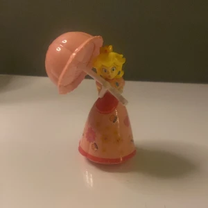 mario peach - en liten prydnad av princess peach från mario 