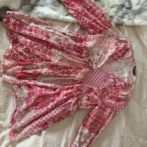 Mönstrad klänning i rosa och rött från Zara - Säljer en vacker klänning med ett mixat mönster i rosa och rött. Klänningen har långa ärmar och en v-ringad design som ger en fin passform. Perfekt för vår och sommar! Säljer då den inte kommer till användning, använd ett fåtal gånger💓Klänningen är i storlek Xs💓Skriv för fler frågor eller bilder 💓!
