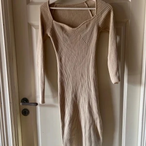 Beige ribbad klänning - Snygg kräm beige ribbad klänning med lång ärm och en unik v-ringad design från SHEIN i storlek S. jätte snygg och bara använt 1 gång 